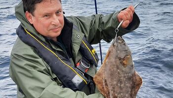 Auch ein kleineHeilbutt sorgt für große Freude: Stolz wird der Fang präsentiert, während im Hintergrund das Meer ruht. Genau solche Augenblicke machen den Reiz des Angelns in Norwegen aus – jeder Fisch ist ein Erlebnis.